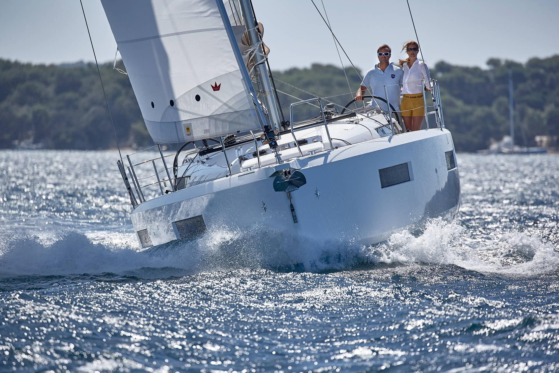 A Jeanneau Sun Odyssey sailing upwind with two people at the helm
